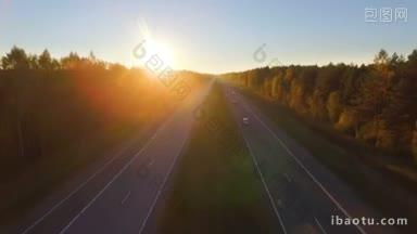 日落时分，一条高速公路的空中全景图，交通沿着阔叶林和针叶林混合而成